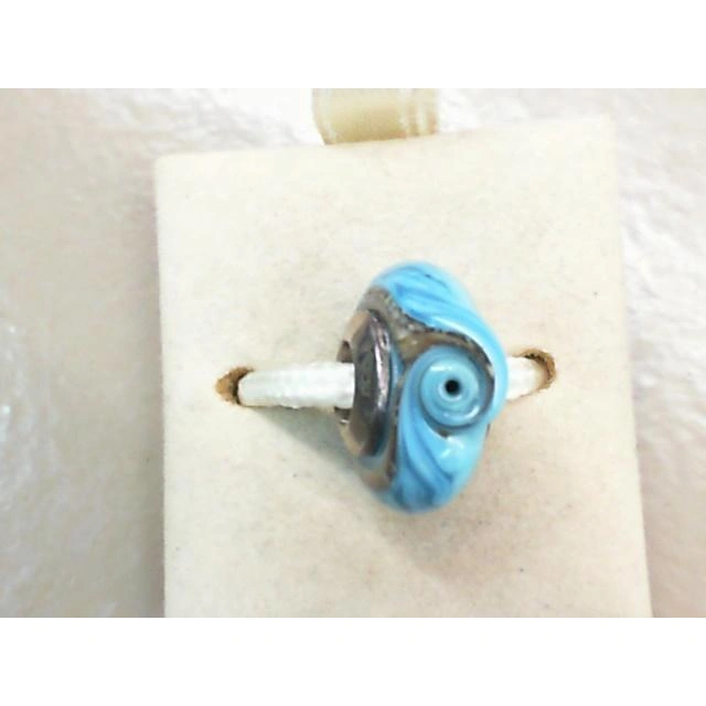 An authentic Sterling Silver bead featuring a unique blue wave design, crafted with intricate details and filled with real sand.