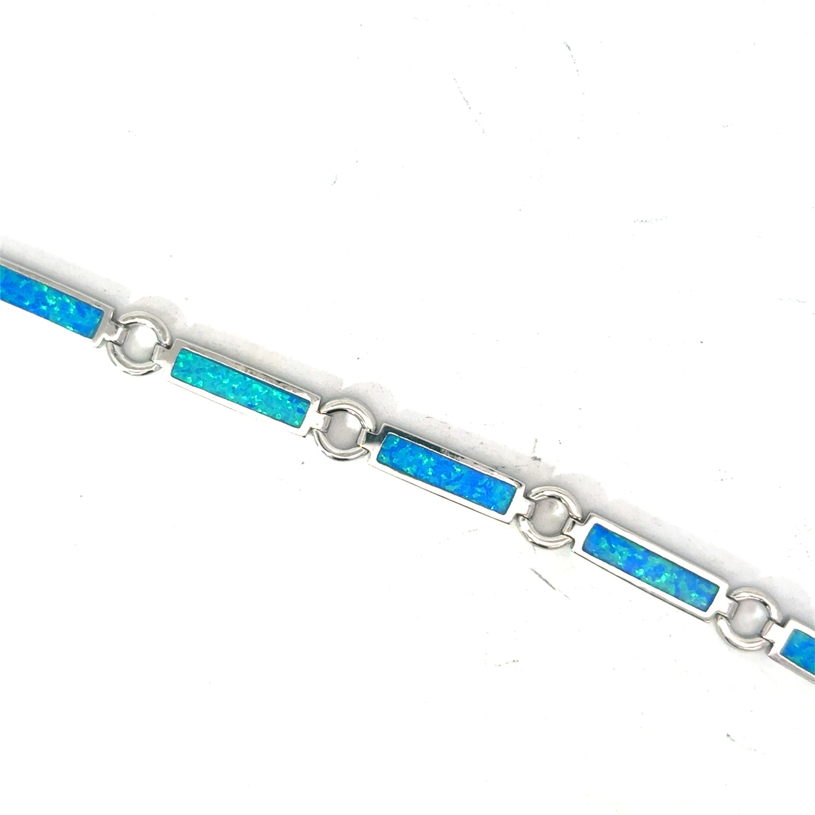 Sterling Silver rhodium plated created blue opal inlay line bracelet with claw catch closure