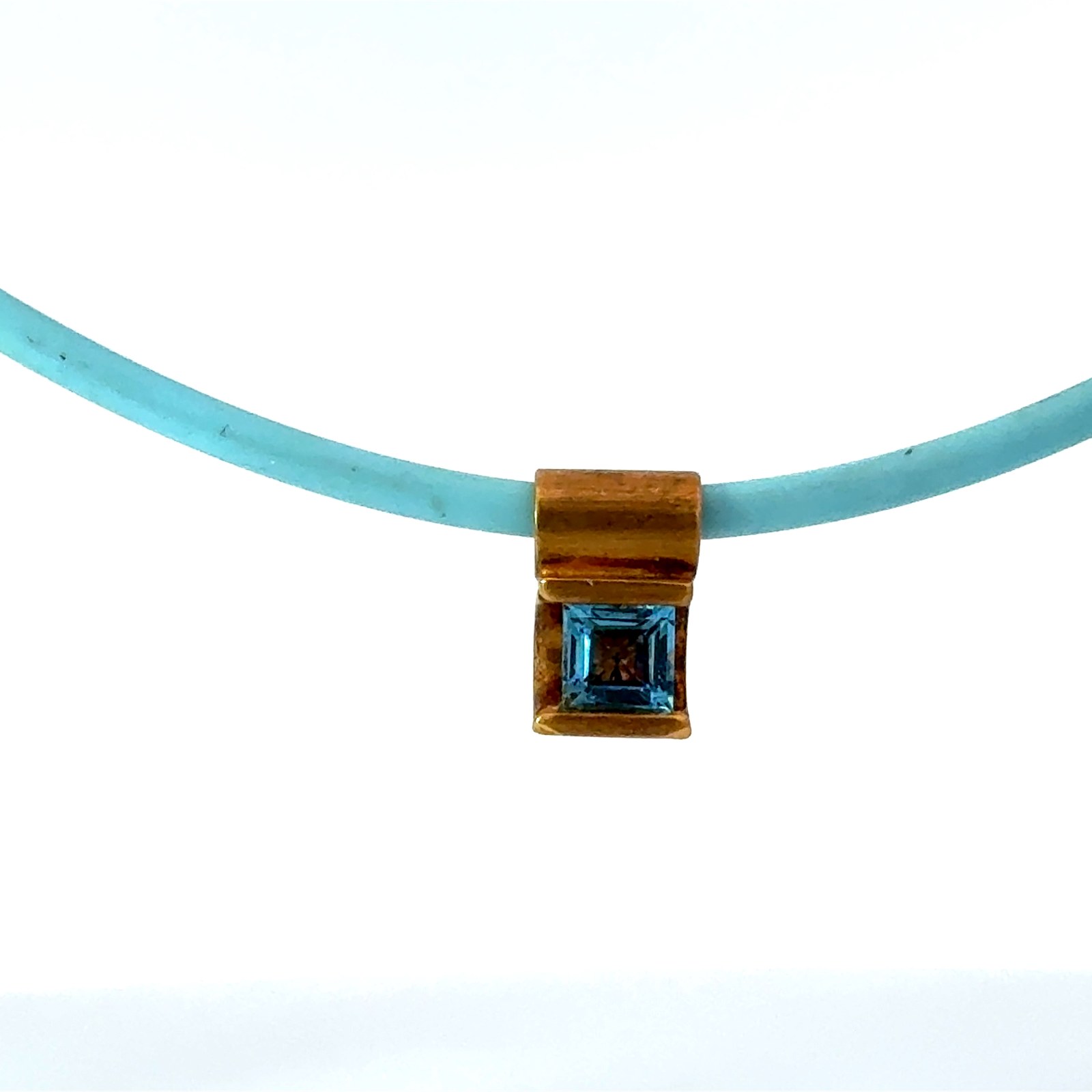 P 14KT Y/G BLUE TOPAZ SQUARE PENDANT ON BLUE CORD